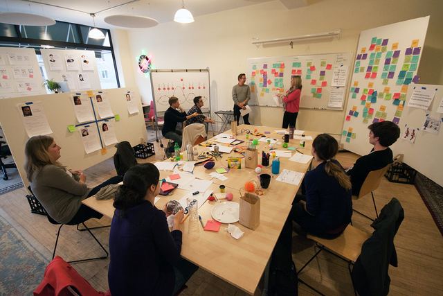 Workshop am grossen Tisch mit Pinnwänden und Haftnotizen